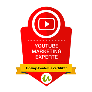 Ein rotes Abzeichen mit einem Wiedergabesymbol und dem Text „YouTube Marketing Experte“ und „Udemy Akademie Zertifikat“.